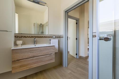 a bathroom with a sink and a mirror at L'Attico di Alessia by BarbarHouse in Maruggio