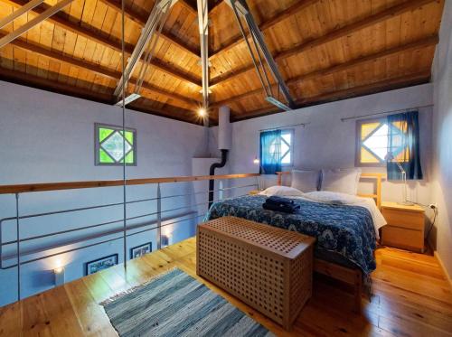 a bedroom with a bed in a room with wooden ceilings at Tsagkarada Country Estate with Pool in Tsagarada