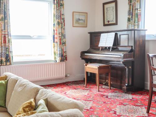 a living room with a piano and a couch at West Croft in Mawbray