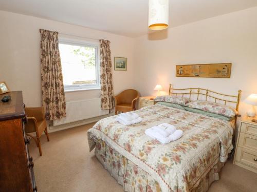 a bedroom with a bed with two towels on it at West Croft in Mawbray