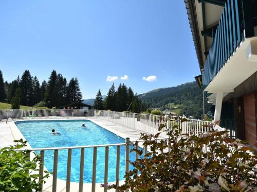 2 personnes nagent dans une piscine dans l'établissement Grizzli- Charmant T2 skis aux pieds, piscine et tennis, accès direct pistes - FR-1-685-57, aux Gets
