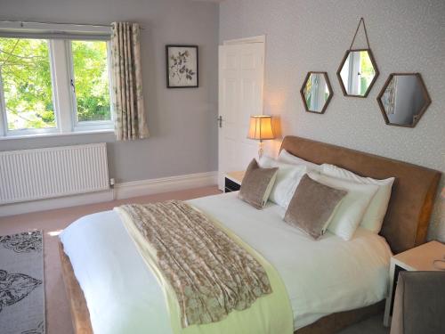 een slaapkamer met een groot wit bed met kussens bij Willow Brook in Glossop