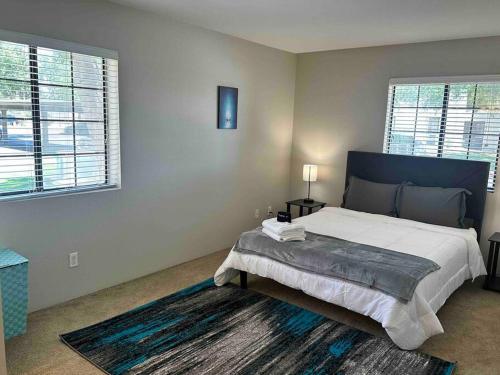 a bedroom with a large bed and two windows at Luxury Tempe Apt by ASU & Airport in Phoenix