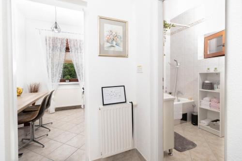 a white bathroom with a table and a desk at Vacation home Ivana in Vukovar