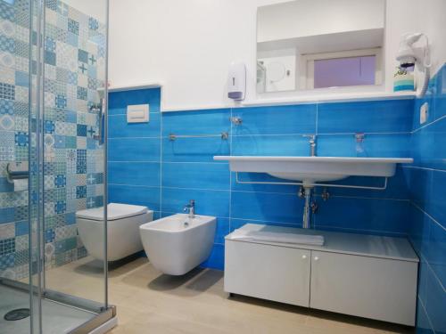 bagno blu con lavandino e servizi igienici di B&B Civico 66 a Diamante