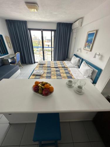 una camera con un letto e un tavolo con frutta di Kassavetis Center - Hotel Studios & Apartments a Hersonissos