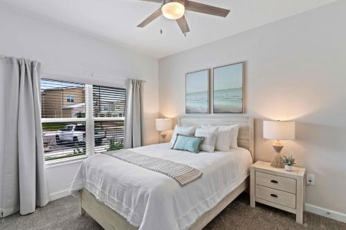 a white bedroom with a bed and a window at 4423 Scene Lane in Kissimmee
