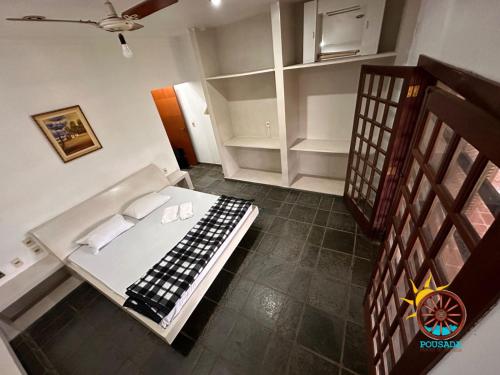 ein kleines Zimmer mit einem Bett und einigen Regalen in der Unterkunft Pousada Rancho na Represa in Nova Odessa
