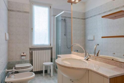 e bagno con lavandino, servizi igienici e doccia. di Casa BELLA - POOL Garden Parking a Polpenazze del Garda