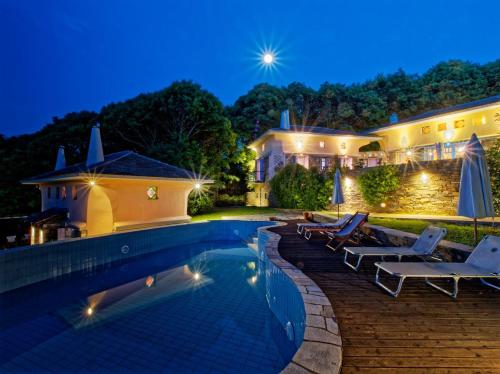 a villa with a swimming pool at night at Tsagkarada Country Estate with Pool in Tsagarada