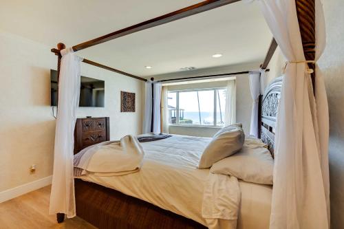 a bedroom with a canopy bed with a window at La Jolla Condo Rental Ocean View, Jetted Tub in San Diego