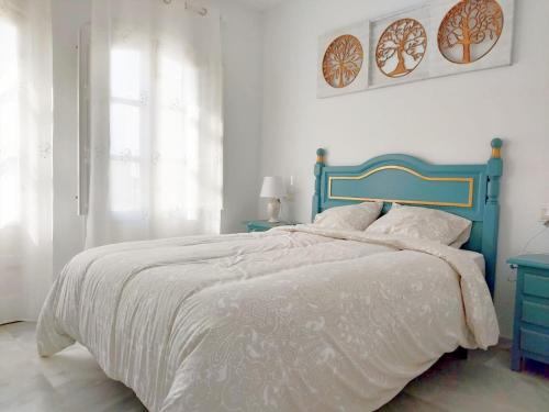 a bed with a blue headboard in a white bedroom at Embrujo de Mojácar in Mojácar
