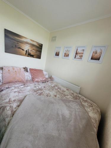 a bedroom with a bed and pictures on the wall at Casa B.R.I in Mablethorpe