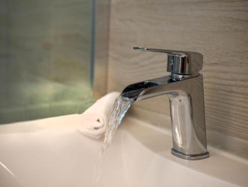- un lavabo avec de l'eau provenant d'un robinet dans l'établissement Sunny Apartments, à Stomorska