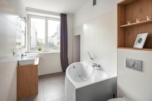 a bathroom with a tub and a sink and a toilet at Sleepy3city Apartments 10 Lutego 23 in Gdynia