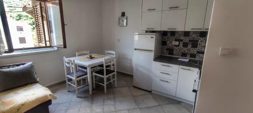a small kitchen with a table and a refrigerator at Laki in Risan