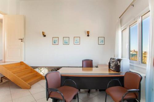 a room with a table and chairs in a room at Crete's Hidden Treasure - Dream Villa with Pool and Majestic Olive Tree Views in Skalánion