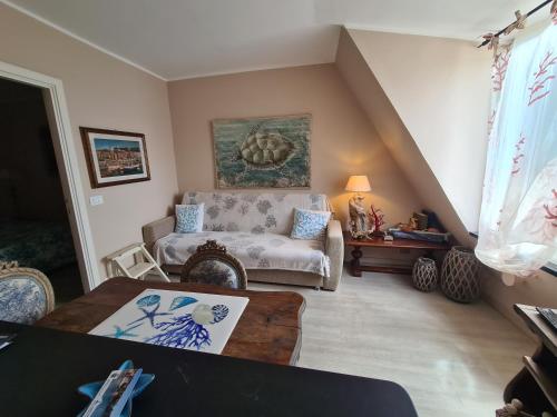 uma sala de estar com um sofá e uma mesa em Splendida mansarda fronte spiaggia la Boheme by PortofinoVacanze em Santa Margherita Ligure