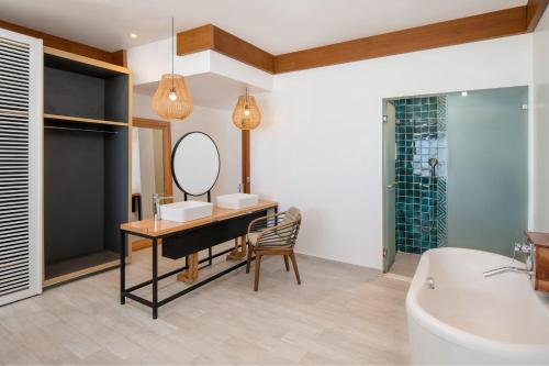 La salle de bains est pourvue d'un lavabo, d'un miroir et d'une baignoire. dans l'établissement Le Mersenne Zanzibar, Autograph Collection, à Michamvi