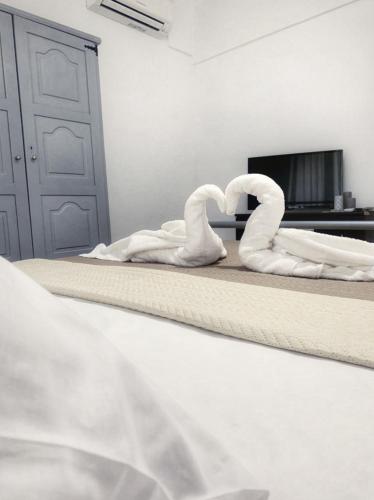 two swans sitting on a bed in a bedroom at Diamond's House in Kallithea Halkidikis