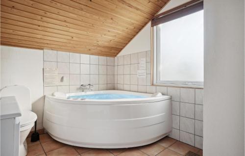 a white bath tub in a bathroom with a window at Stunning Home In Thisted With 4 Bedrooms, Sauna And Wifi in Nørre Vorupør