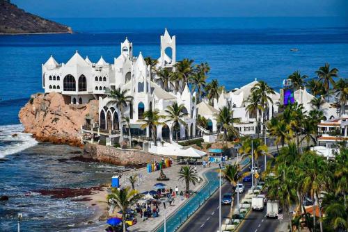 einen Luftblick auf ein Resort mit Palmen und dem Meer in der Unterkunft Dodo Estadio in Mazatlán