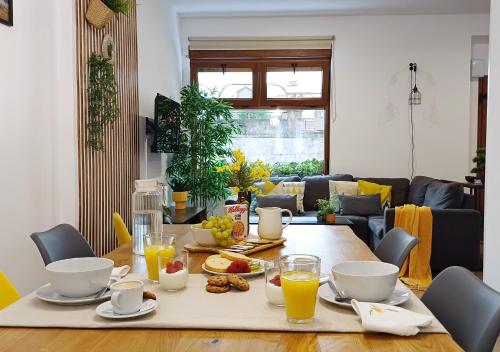 a dining room table with breakfast foods and orange juice at LOFT de Tita Larrea in Arriondas