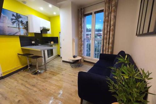 un salon avec un canapé et une cuisine dans l'établissement Duplex T2 Neuf Jardin Lecoq, à Clermont-Ferrand