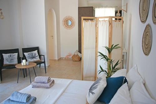 een woonkamer met een wit bed en een tafel bij Fereniki's place in Gaios