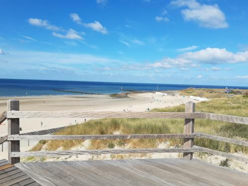 een uitzicht op een strand vanaf een houten promenade bij 't KISTJE Bed by the Sea in Koudekerke