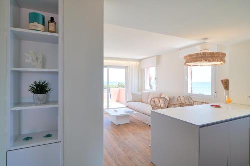 eine weiße Küche und ein Wohnzimmer mit einem Sofa in der Unterkunft Sea Suite in Marbella