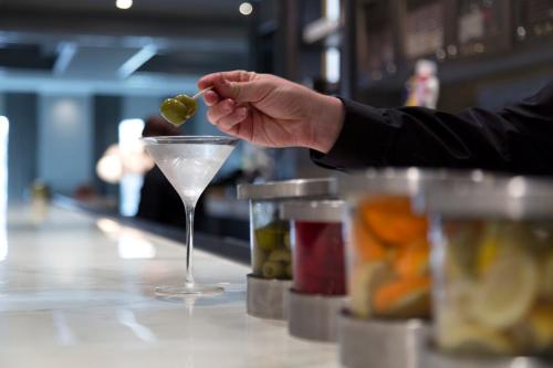 a person holding a green olive in a martini glass at Franklin Marriott Cool Springs in Franklin