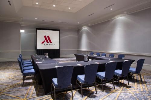 a conference room with a table and chairs and a screen at Franklin Marriott Cool Springs in Franklin