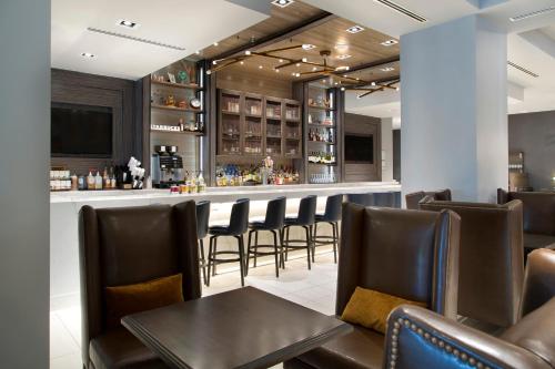 a bar in a restaurant with leather chairs and a table at Franklin Marriott Cool Springs in Franklin