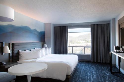 a hotel room with a bed and a table and a window at Franklin Marriott Cool Springs in Franklin