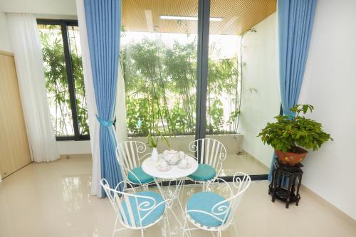 a room with a table and chairs and a window at Truc Home in Danang