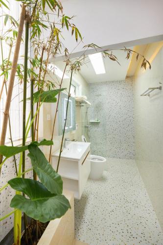 a bathroom with a sink and a toilet and a plant at Truc Home in Da Nang