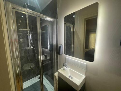 a bathroom with a shower and a sink and a mirror at The Retreat in Doncaster