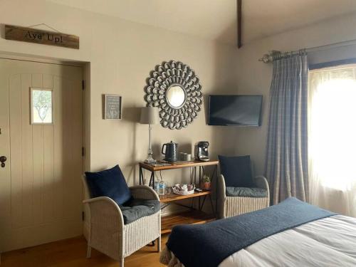 sypialnia z łóżkiem, 2 krzesłami i lustrem w obiekcie The Retreat w mieście Doncaster