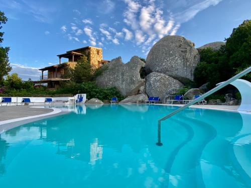 een zwembad met blauw water en rotsen bij Oasi Verde Acqua - Country Porto Rotondo in Porto Rotondo