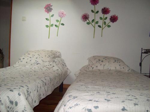 - 2 lits dans une chambre ornée de fleurs sur le mur dans l'établissement LA CORSE la montagne, les plages, les iles, à Monticello