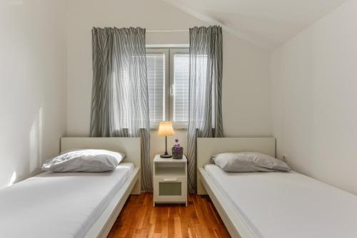 a bedroom with two beds and a table with a lamp at Zara 1 in Kruševo
