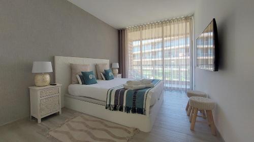 - une chambre avec un grand lit et une fenêtre dans l'établissement Apartamentos Herdade dos Salgados - Vila das Lagoas, à Albufeira