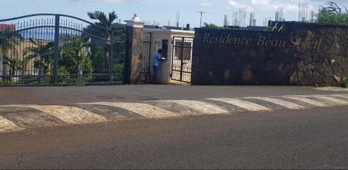 a man standing in front of a gate with a sign at Casa JEM in Albion