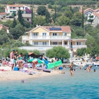 a group of people on a beach near the water at Sunce Mobile Homes & apartments in Grebaštica