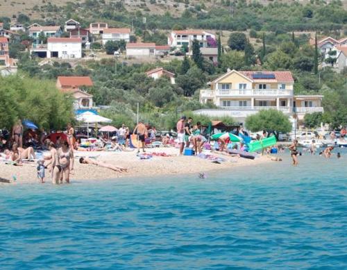 a group of people on a beach near the water at Sunce Mobile Homes & apartments in Grebaštica