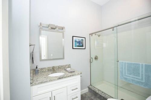 La salle de bains est pourvue d'une douche en verre et d'un lavabo. dans l'établissement Portside Elegance, Chic Urban Haven, à Portland