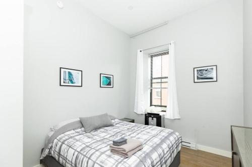 Portside Elegance, Chic Urban Haven في بورتلاند: غرفة نوم بيضاء بها سرير ونافذة