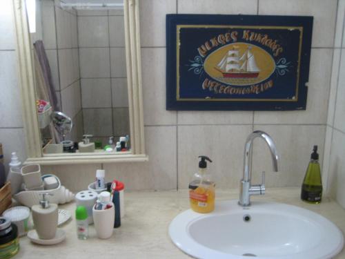 un bancone del bagno con lavandino e specchio di Olive House a Kalamákion