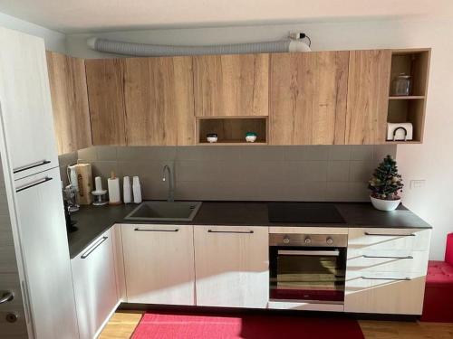 - une cuisine avec des placards en bois et un arbre de Noël dans l'établissement Appartamento nuovo tra Bormio e Livigno, à Valdidentro